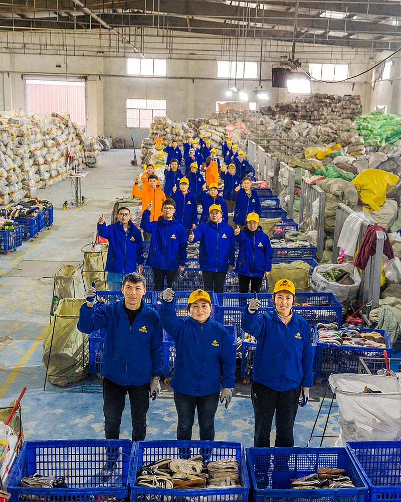 King AAA Guangzhou factory team of 600 workers in blue workwear and yellow caps sorting used clothing bales for wholesale export to 120+ countries