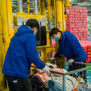 KingAAA workers packing sorted used clothing into export bales at our Guangzhou facility.