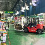 KingAAA workers palletizing and stacking sorted used clothing bales in Guangzhou warehouse for container loading.