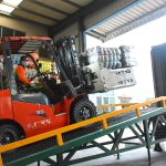 KingAAA workers loading wholesale used clothing bales into 40ft container for export to Africa and the Middle East.